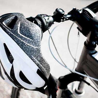 Detail go a bicycle helmet hanging from a mountain bike handlebar